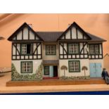 A LARGE WOODEN DOLL'S HOUSE IN A MOCK TUDOR STYLE TO INCLUDE SOME FURNITURE