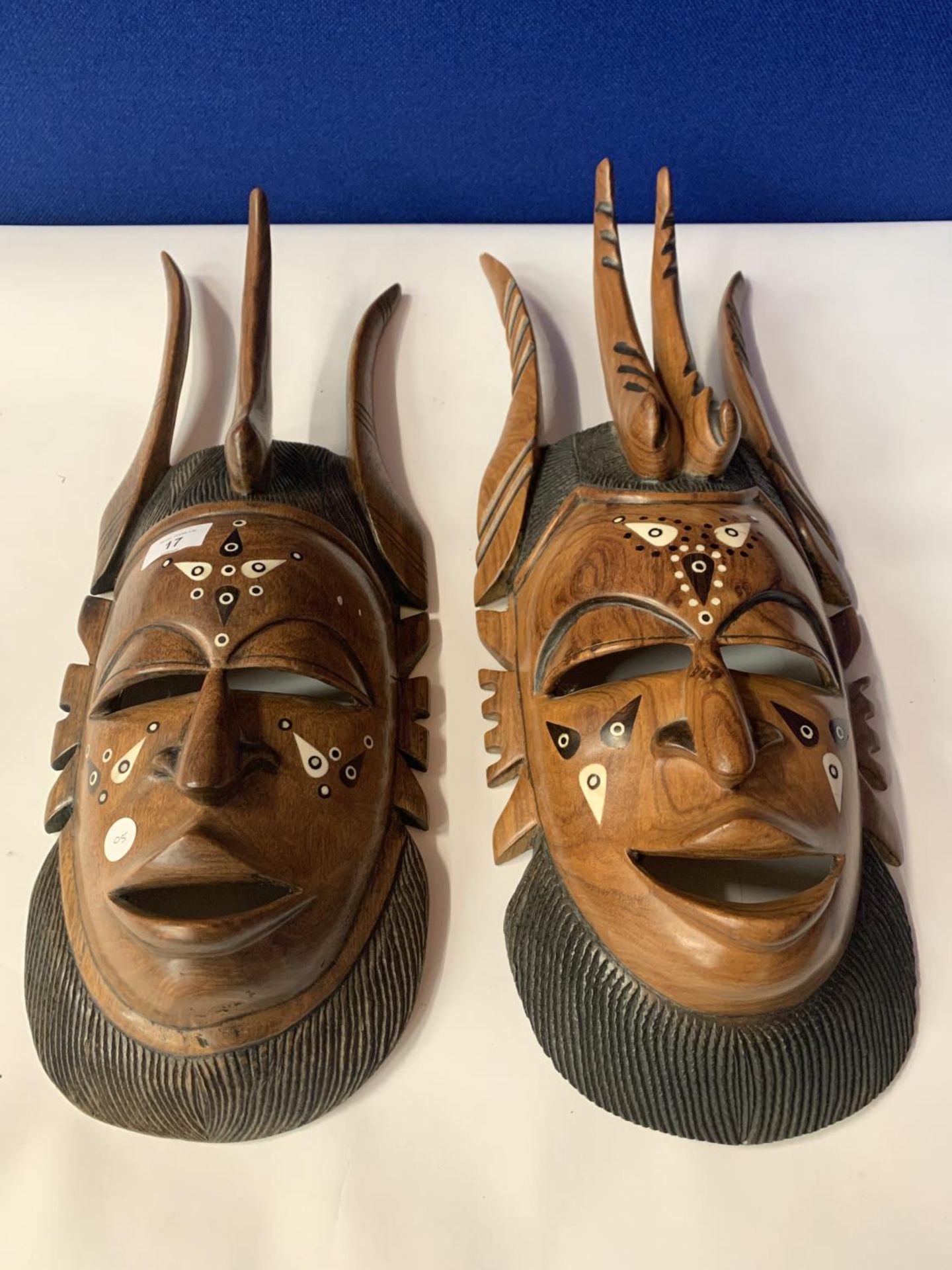 A PAIR OF HEAVILY CARVED INLAID TRIBAL MASKS