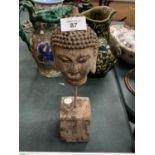 AN ANTIQUE STYLE STONE BUDDHA HEAD ON A STEEL PLINTH