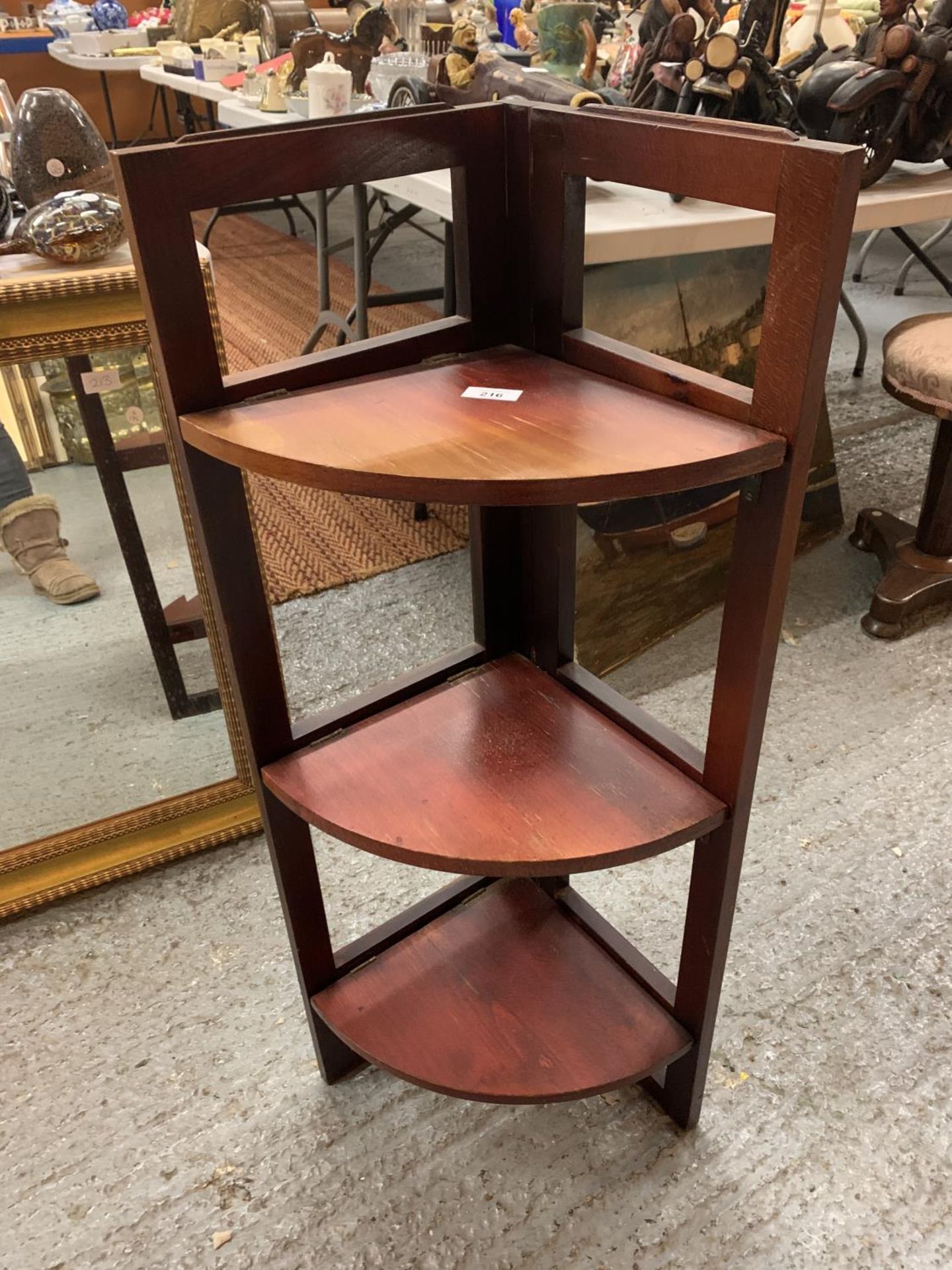 A WOODEN THREE SHELF FOLDING CORNER STAND