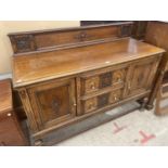 AN EARLY 20TH CENTURY OAK JACOBEAN STYLE SIDEBOARD WITH RAISED BACK AND TURNED FRONT LEGS, 59" WIDE