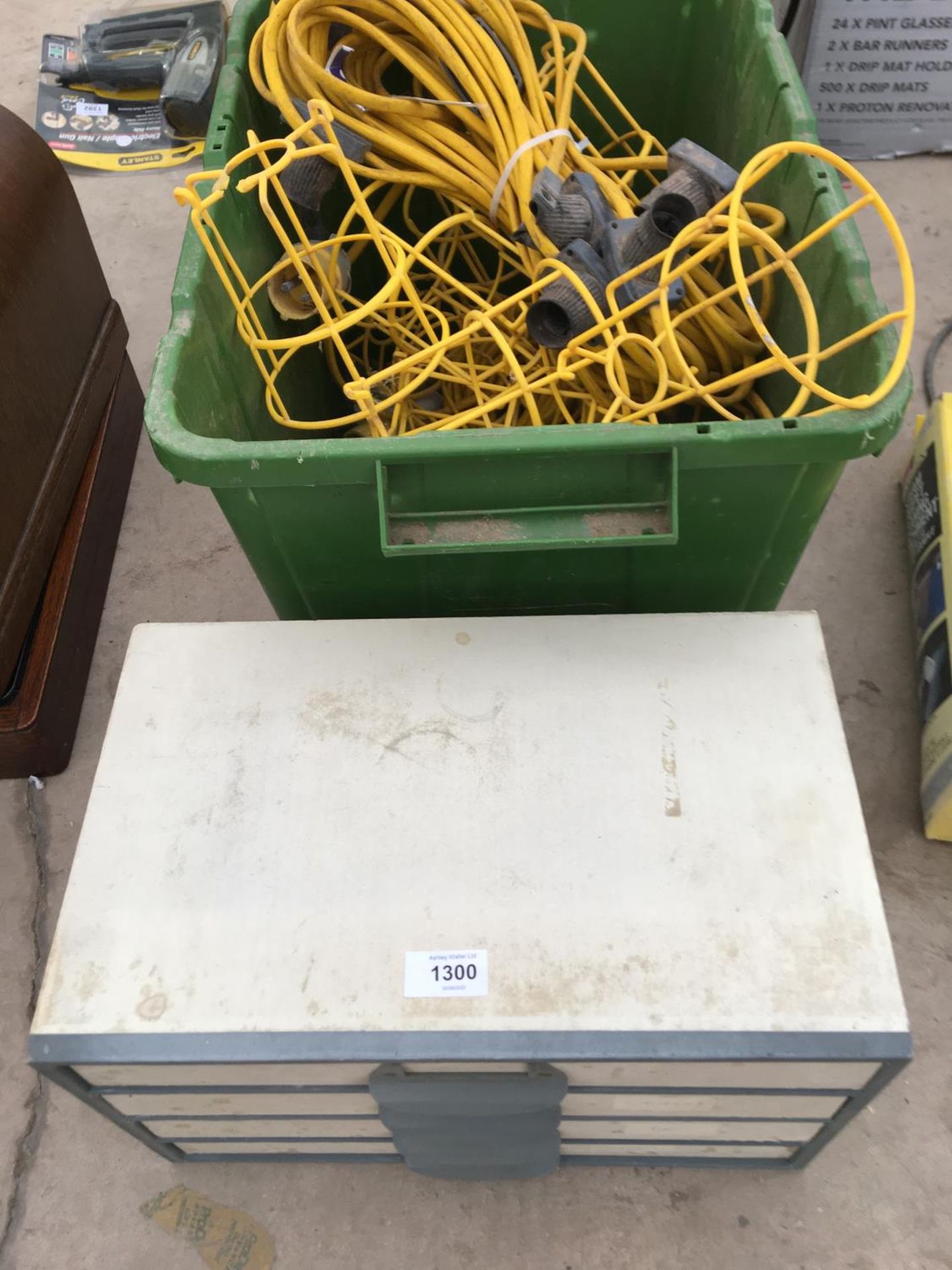 A SMALL SET OF WOODEN DRAWERS AND A BOX OF YELLOW EXTENSION 110V LEADS FOR LIGHT FITTINGS ETC.