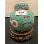 A CHINESE GINGER JAR WITH LID ON A CARVED WOODEN BASE