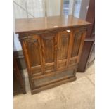 AN OLD CHARM OAK GOTHIC STYLE TV/VIDEO CABINET WITH GLAZED AND LEADED DROP-DOWN PANEL, 33" WIDE