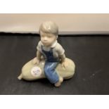 A ROYAL COPENHAGEN FIGURE OF A BOY SITTING ON A MARROW