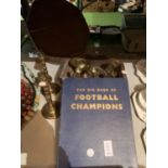 AN OCTAGONAL WOODEN BOX CONTAINING THREE SETS OF BRASS CANDLESTICKS AND FOOTBALL CHAMPIONS BOOK