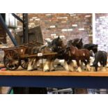 A LARGE SHIRE HORSE AND WOODEN CART WITH FOUR OTHER CERAMIC SHIRE HORSES