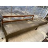 AN OAK FRAMED LONG UPHOLSTERED BENCH SEAT AND MATCHING LONG STOOL, 67" WIDE