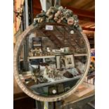 A ROUND VINTAGE MIRROR WITH FLOWER DECORATION