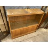 A VINTAGE LIGHT OAK BOOKCASE WITH SLIDING GLASS DOORS TO UPPER PORTION AND SLIDING WOODEN DOORS TO