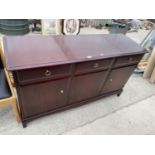 A STAG MINSTREL MAHOGANY SIDEBOARD WITH THREE DOORS AND THREE DRAWERS