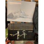 TWO LARGE PRINTS, ONE OF A RECLINING FEMALE AND ANOTHER BANKSY IMAGE OF TWO MEN FIRING BANANAS