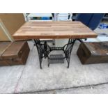 A PARQUET TOP TABLE WITH SINGER TREADLE SEWING MACHINE BASE