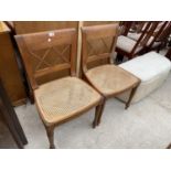 A PAIR OF HARDWOOD DINING CHAIRS WITH CANE SEATS AND BACKS, COMPLETE WITH UPHOLSTERED OTTOMAN