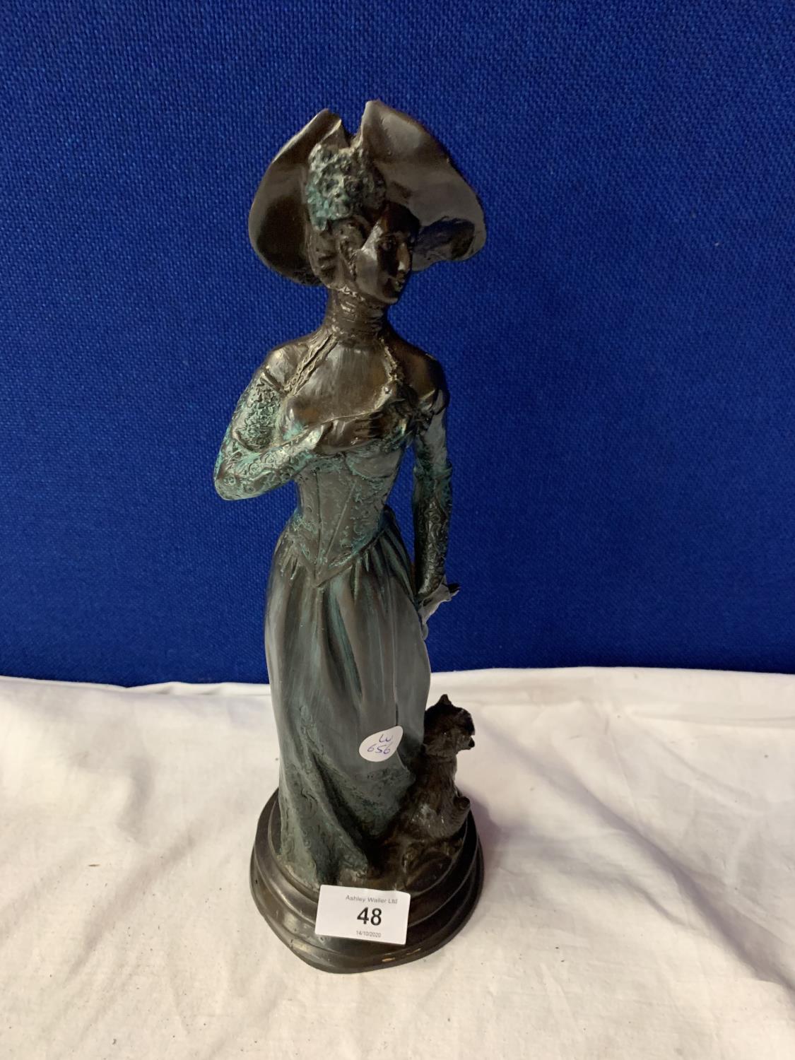 A BRONZE FIGURINE AN OF EDWARDIAN LADY WITH HER DOG