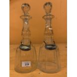 A PAIR OF CUT GLASS DECANTERS WITH SILVER PLATED CLARET AND SHERRY LABELS