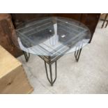 A GLASS TOP COFFEE TABLE ON METAL BASE