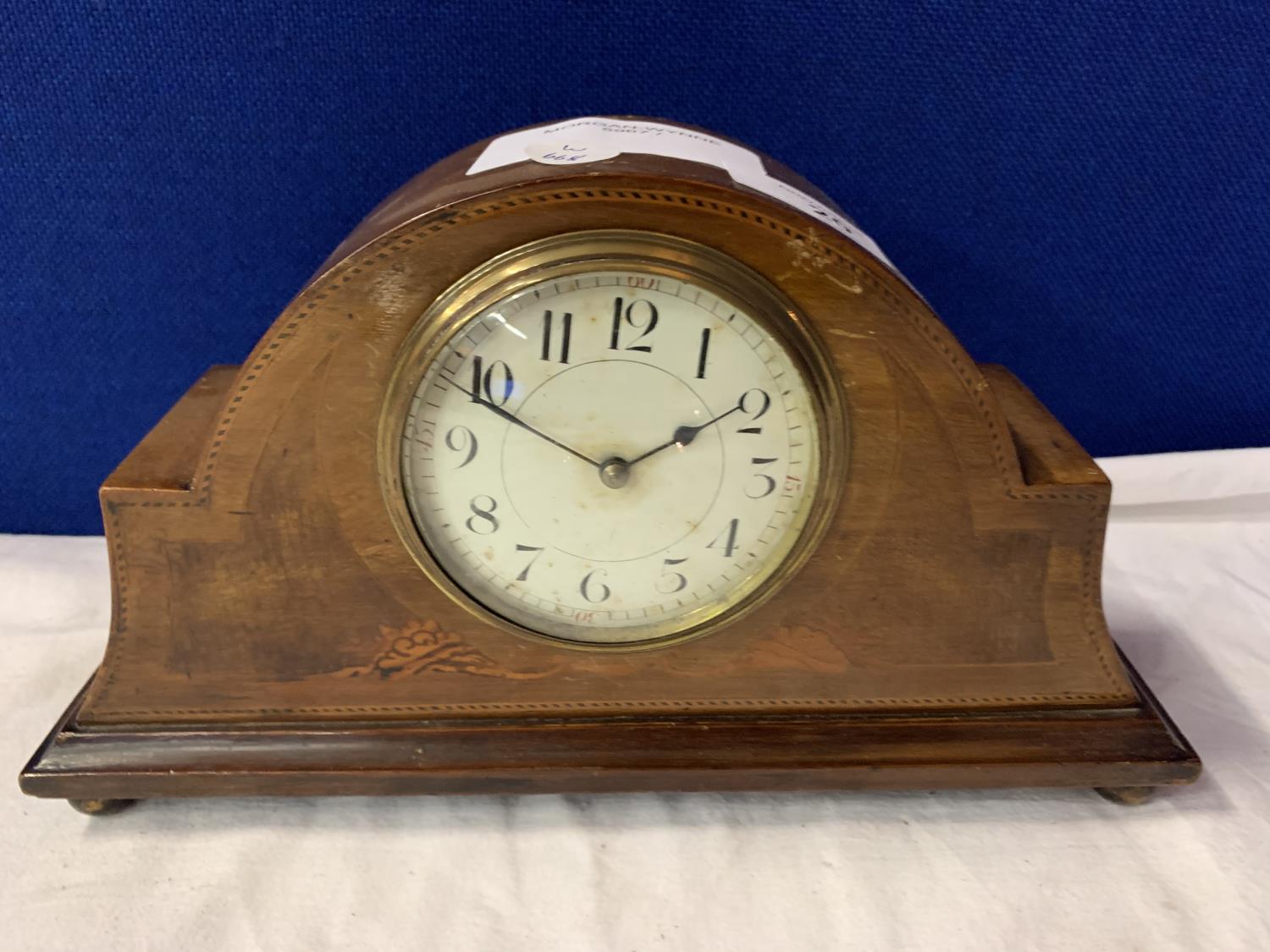 A WOODEN MANTLE CLOCK WITH INLAY DETAIL AND BRASS FACE SURROUND
