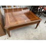 A MODERN WALNUT CROSSBANDED COFFEE TABLE, ON TURNED AND FLUTED LEGS, 35" SQUARE