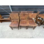 A SET OF SIX CARVED OAK DINING CHAIRS WITH STUDDED LEATHER SEATS AND BACKS (INCLUDING ONE CARVER)