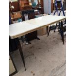 A RETRO FORMICA TOP KITCHEN DINING TABLE WITH EXTRA LEAF WITH METAL SUPPORTING LEGS