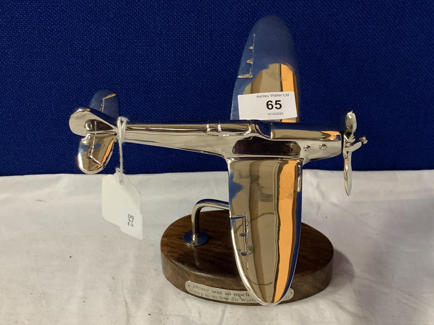 A CHROME MODEL OF A SPITFIRE ON A WOODEN BASE