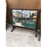 A WOODEN FRAMED PIVOT DRESSING TABLE MIRROR WITH BRASS FINIALS