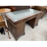 A MID 20TH CENTURY OAK KNEEHOLE DESK WITH NINE DRAWERS AND AN INSET LEATHER TOP, 42x27"