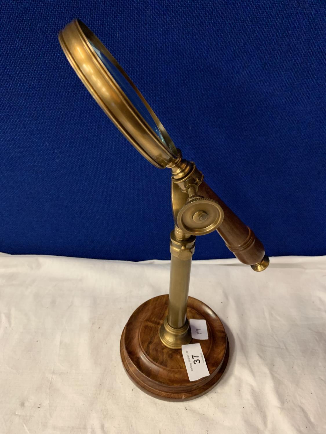 A VINTAGE BRASS MAGNIFTING GLASS ON A WOOD AND BRASS STAND - Image 2 of 3