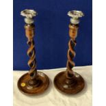 A PAIR OF VINTAGE WOODEN CANDLESTICKS IN A TWISTED DESIGN WITH WHITE METAL TOPS