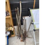 A COLLECTION OF VINTAGE GARDEN TOOLS TO INCLULDE PICK AXE, FORK, SPADE ETC.