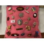 A QUANTITY OF BROOCHES TO INCLUDE CAMEOS ON A PINK FELT CUSHION