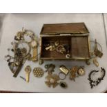 A YELLOW METAL MUSIC BOX CONTAINING AN ASSORTMENT OF COSTUME JEWELLERY