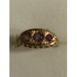 AN ORNATE 9 CARAT GOLD RING WITH THREE PURPLE STONES