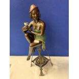 A BRONZE FIGURINE OF A SEMI-NUDE POSED ON A TALL STOOL IN AN ART DECO STYLE