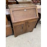AN OAK BUREAU WITH FALL FRONT AND TWO DOORS