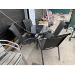A METAL GARDEN TABLE WITH BLACK GLASS TOP AND FOUR GARDEN CHAIRS