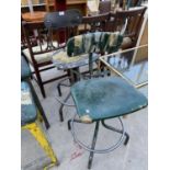 A PAIR OF INDUSTRIAL SWIVEL ADJUSTABLE CHAIRS ON STEEL BASES