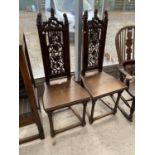 A PAIR OF VICTORIAN OAK GOTHIC STYLE HALLCHAIRS WITH CARVED FRETWORK FOLIATE BACKS, ON TURNED