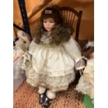 A LARGE PORCELAIN HEADED DOLL CALLED ALISON IN A WOODEN ROCKING CHAIR