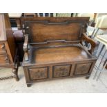 AN EARLY 20TH CENTSURY OAK MONKS BENCH WITH CARVED THREE PANEL FRONT, 43" WIDE