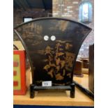 A BLACK WOODEN MAGAZINE RACK WITH ORIENTAL DESIGN