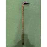 A GREEN WOODEN WALKING STICK WITH A PAINTED DRAKE'S HEAD HANDLE