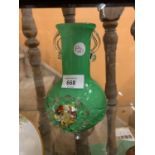 A GREEN GLASS VASE WITH ORNATE FLOWER DESIGN