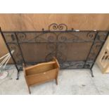 A LARGE VERY HEAVY ORNATE FIRE GUARD, WIDTH 123CM, HEIGHT 83CM AND A TEAK MAGAZINE RACK