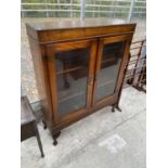 AN EARLY 20TH CENTURY OAK TWO DOOR BOOKCASE ON CABRIOLE LEGS