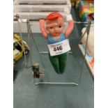 A VINTAGE WIND UP AND WEIGHED GYMNAST PERFORMING ON THE HIGH BAR