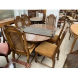 A CONTINENTAL STYLE EXTENDING DINING TABLE AND SIX DINING CHAIRS WITH CANE BACKS (4+2)