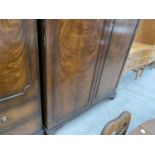 A REPRODUCTION MAHOGANY TWO DOOR WARDROBE AND MATCHING WARDROBE WITH TWO DRAWERS TO BASE, BY