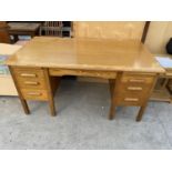 A MID 20TH CENTURY LIGHT OAK ABBESS ENDURING WOODWARE TWIN PEDESTAL DESK ENCLOSING SIX DRAWERS AND